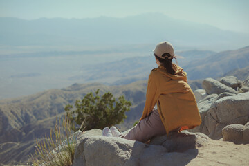 Travel, The woman is sitting at the top of the mountain looking at the beautiful panoramic view.