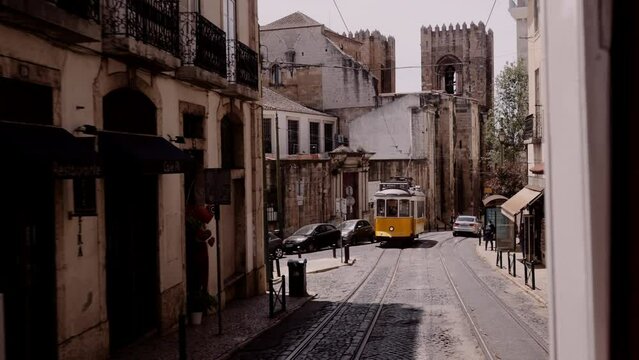 Old yellow tram on a street in Lisbon.