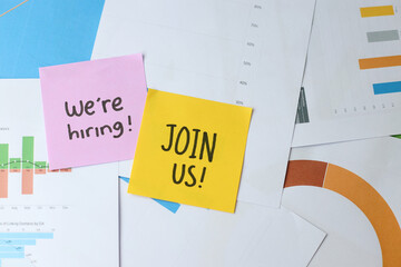 Were Hiring And Join Us Written On Colorful Sticky Note Against Paperwork Background