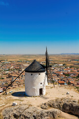 Nice view of an old windmill on a hill and the town of Consuegra in the background, Toledo, Castilla la Mancha, Spain