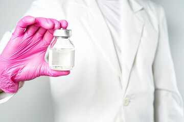 virus vaccine bottle for injection in hand of doctor or Technician scientist