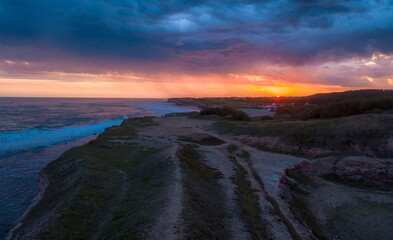 Horizonte acantilado al borde del mar durante el atardecer nublado 