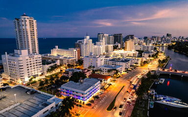 Obraz premium Miami Beach, Florida, USA - Scenic aerial of hotels and luxury apartment buildings lining the beach during the evening.