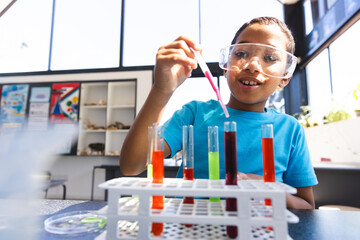 Biracial boy conducts an experiment in a science classroom at school
