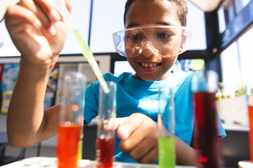 Biracial boy engaged in a science experiment at school