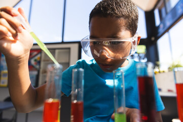 Biracial boy explores science experiment at school in the classroom