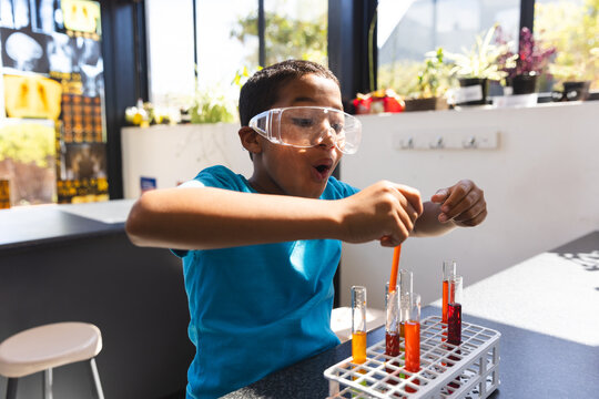 Biracial boy engages in a science experiment at home