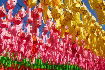 Colorful lanterns under blue sky in Thailand during Loy Krathong festival.