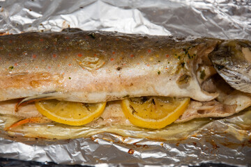 Fried trout with lemon in aluminum foil
