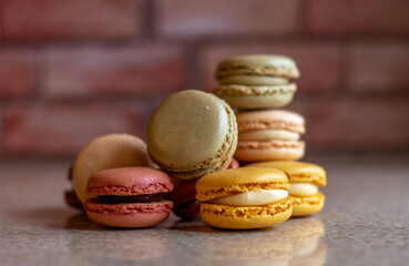 Pile of sweet macarons cookies against a brick wall back ground
