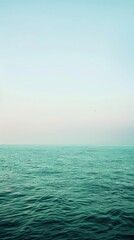 Obraz premium A calm blue ocean with a clear sky above