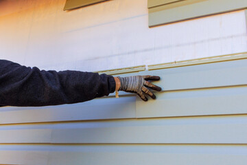 Damaged plastic siding is replaced as part of exterior house remodel