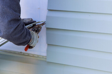 During exterior house renovations, damaged plastic siding is replaced