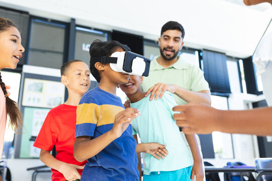 In school, young students and their Asian teacher are exploring virtual reality