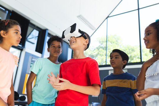 In school, group of biracial young students are exploring virtual reality
