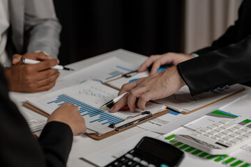 team of marketing is meeting about company finance, an employee is using calculator to calculate...