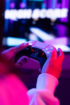 A biracial young girl holding game controller at home, focusing on playing