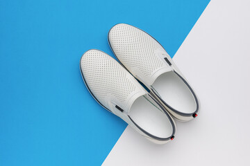 Stylish White Slip-On Shoes on Blue and White Background - Footwear, Fashion, Casual Wear