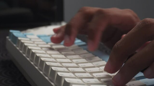 hands typing on wireless keyboard on desk