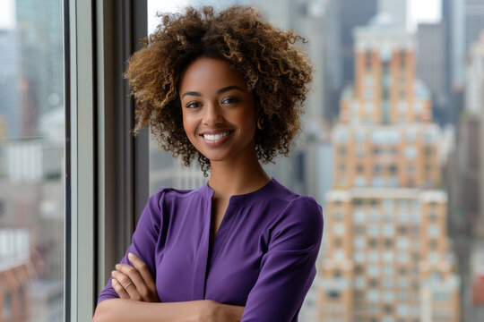 Afro businesswoman wearing purple formal shirt standing in modern office