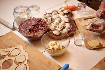 family at the table in the kitchen making dumplings