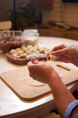 family at the table in the kitchen making dumplings