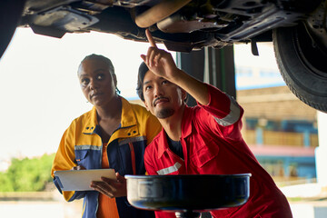 Technician team try to check up and replace engine oil in maintain time service in car garage.