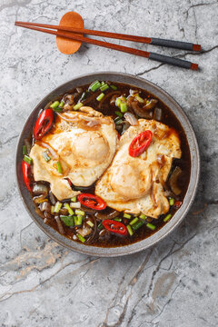 Malaysian simple food soy sauce eggs telur masak kicap closeup on the plate on the table. Vertical top view from above