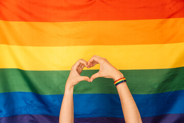 Fototapeta premium Hands showing heart and love against LGBT flag.