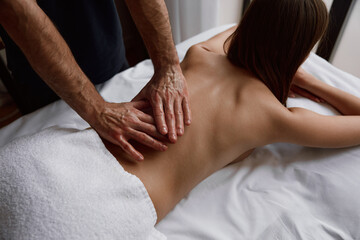 Woman receiving osteopathic back massage for muscle pain relief