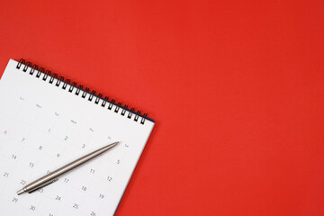 A pen with calendar on red background..