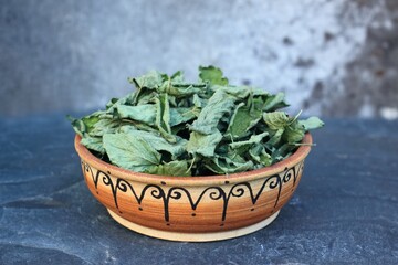Dried  Melissa officinalis leaves in a bowl.  Commonly known as lemon balm or melissa. In...