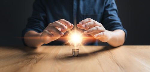 Businessman protect light bulb, Creative new idea. Innovation, brainstorming, inspiration and...