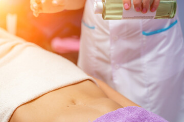 Top view of hands massaging female abdomen.Therapist applying pressure on belly. Woman receiving...