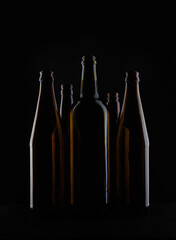 Several beer bottles on a dark background in backlight.