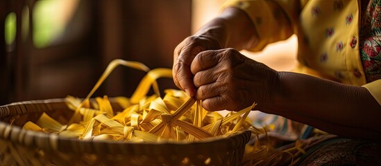 Woman's hands weaving a bamboo basket in a copy space image.