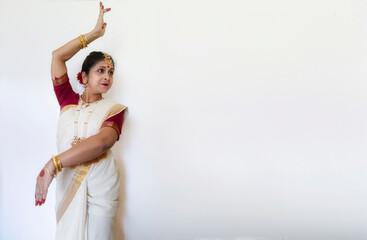 Female Indian classical dancer in Bharatanatyam dance mudra on white background with copy-space.