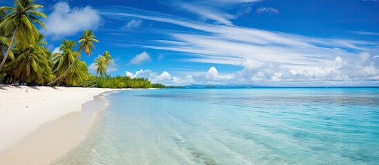 A serene tropical beach scene with a blue sky, white clouds, and a vintage color filter, serving as a copy space image for summer vacation and travel.