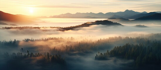 Fototapeta premium A stunning aerial view of a mountain peak surrounded by clouds at sunrise in summer, showcasing a beautiful landscape with rocky terrain, dense forests, and a cloudy sky, ideal for a copy space image.