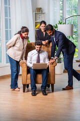 Group of young Indian asian business professionals using laptop in office