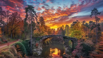 Fantastic autumn landscape with vibrant sunset in azalea and rhododendron park, kromlau - stunning view of rakotz bridge (rakotzbrücke) in saxony, germany