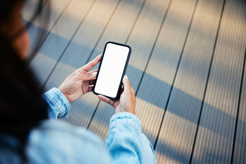 Woman holding smartphone with mockup blank screen with terrace in background