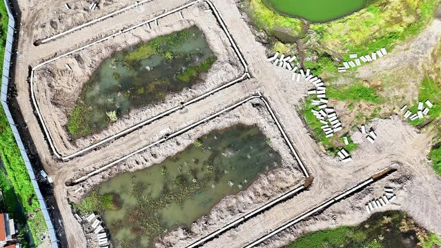 residential industry, construction of water channels in housing. The excavator lifts the culvert for the process of making waste water drainage channels.