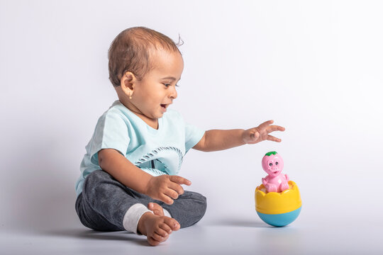 Joyful baby playing with toys. baby boy fun play with rolly polly toy. Little baby kid playing with balancing doll.