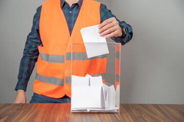 A voter casting a ballot into a ballot box on election day. Referendum, democracy,  plebiscite,...