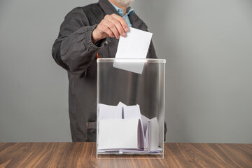 A voter casting a ballot into a ballot box on election day. Referendum, democracy,  plebiscite,...