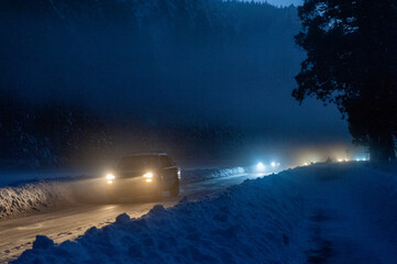 A line of cars, just after sunset, leaving a snow-covered Yosemite national park.