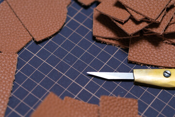 茶色のカットされたレザー皮革とカッターの刃