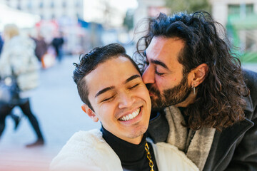 Man with long hair and beard kissing another man