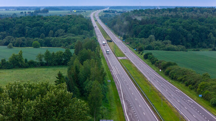 Cars movement on a highway, aerial view. Car traffic on a suburban highway in summer day. Logistic...